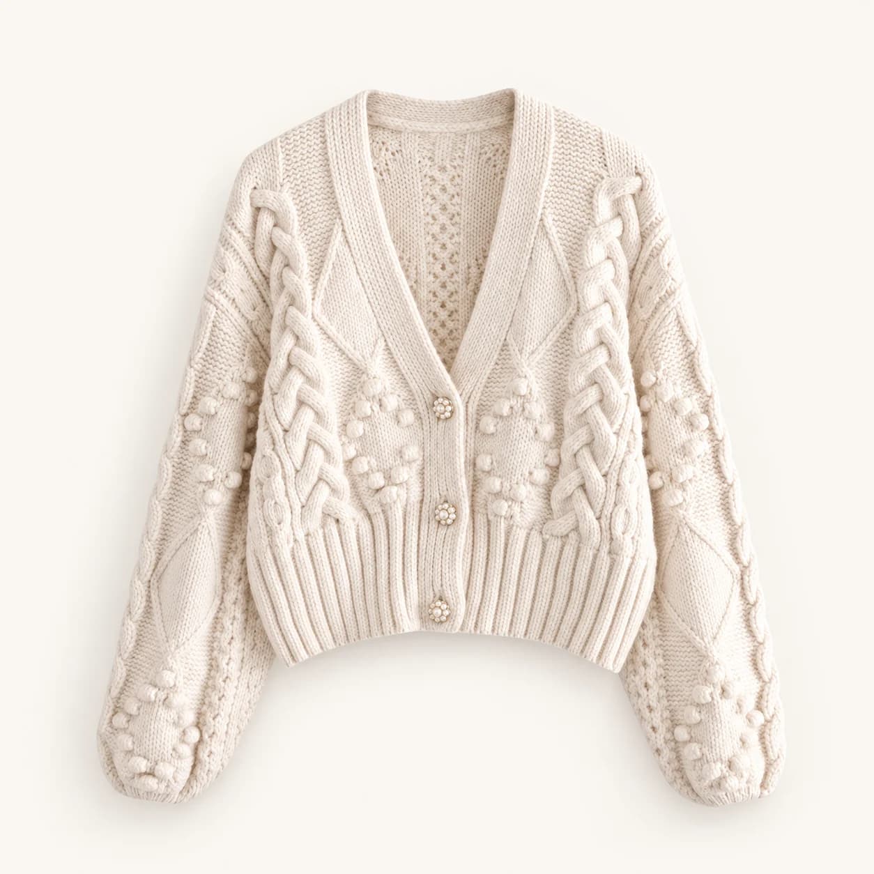 Ivory cropped V-neck cardigan with cable and bobble knit detailing and three decorative buttons Ivory cropped V-neck cardigan with cable and bobble knit detailing and three decorative buttons