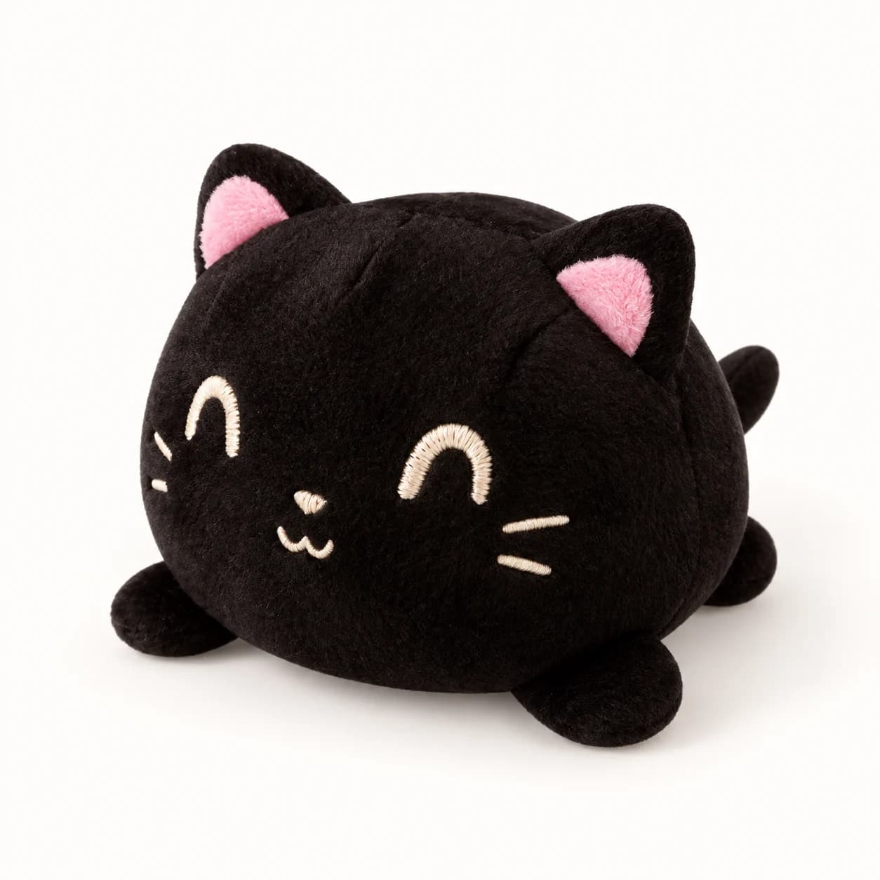 Black Reversible Cat Plush with smiling embroidered face and pink ears, happy side Black Reversible Cat Plush with smiling embroidered face and pink ears, happy side